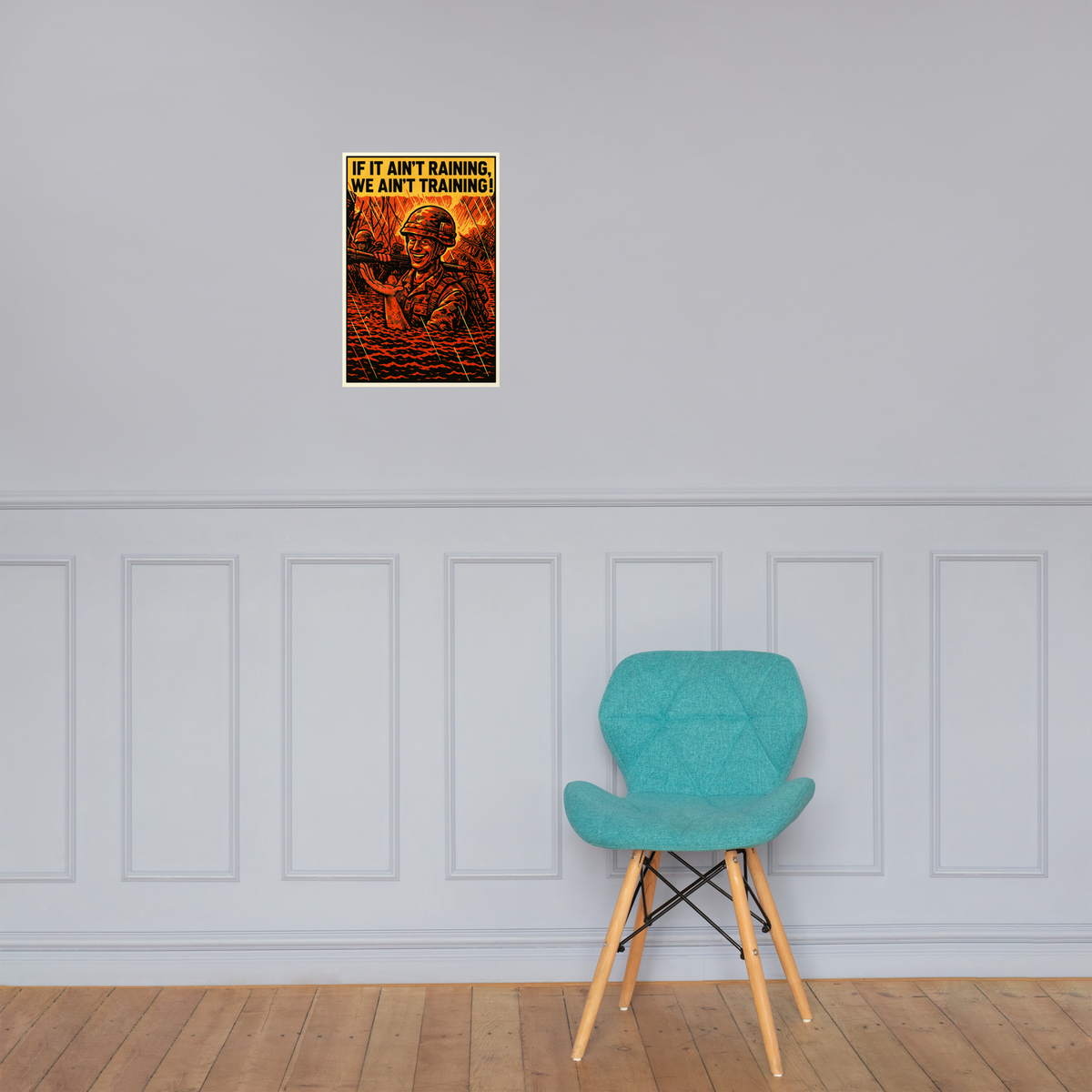 If It Ain't Raining, We Ain't Training! 2: 12 in by 18 in glossy poster on a paneled wall above a turquoise chair; Printful room mockup.